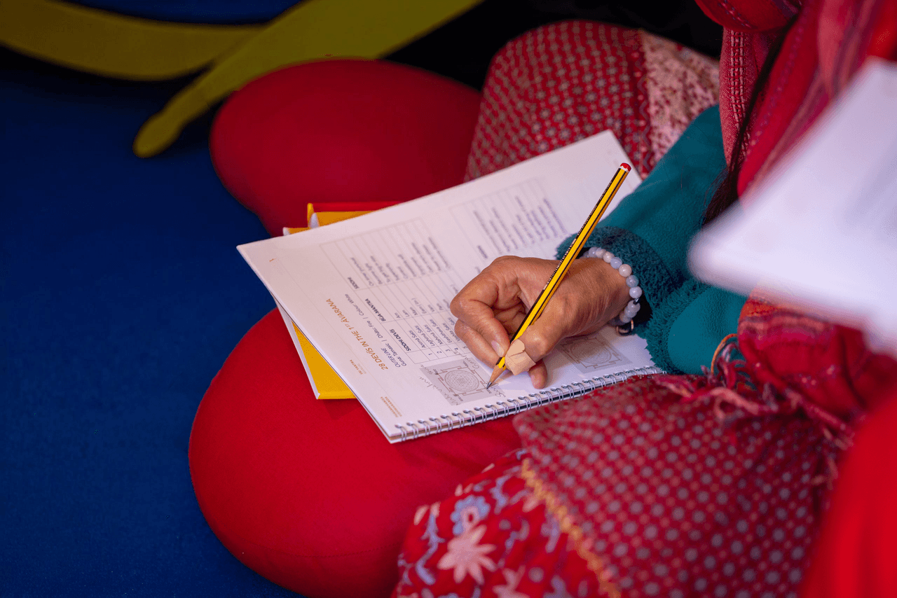 Hands writing notes during the Sri Yantra course